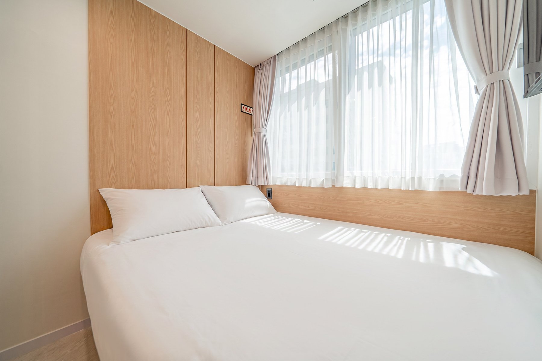Guest room with sheer curtains and window light